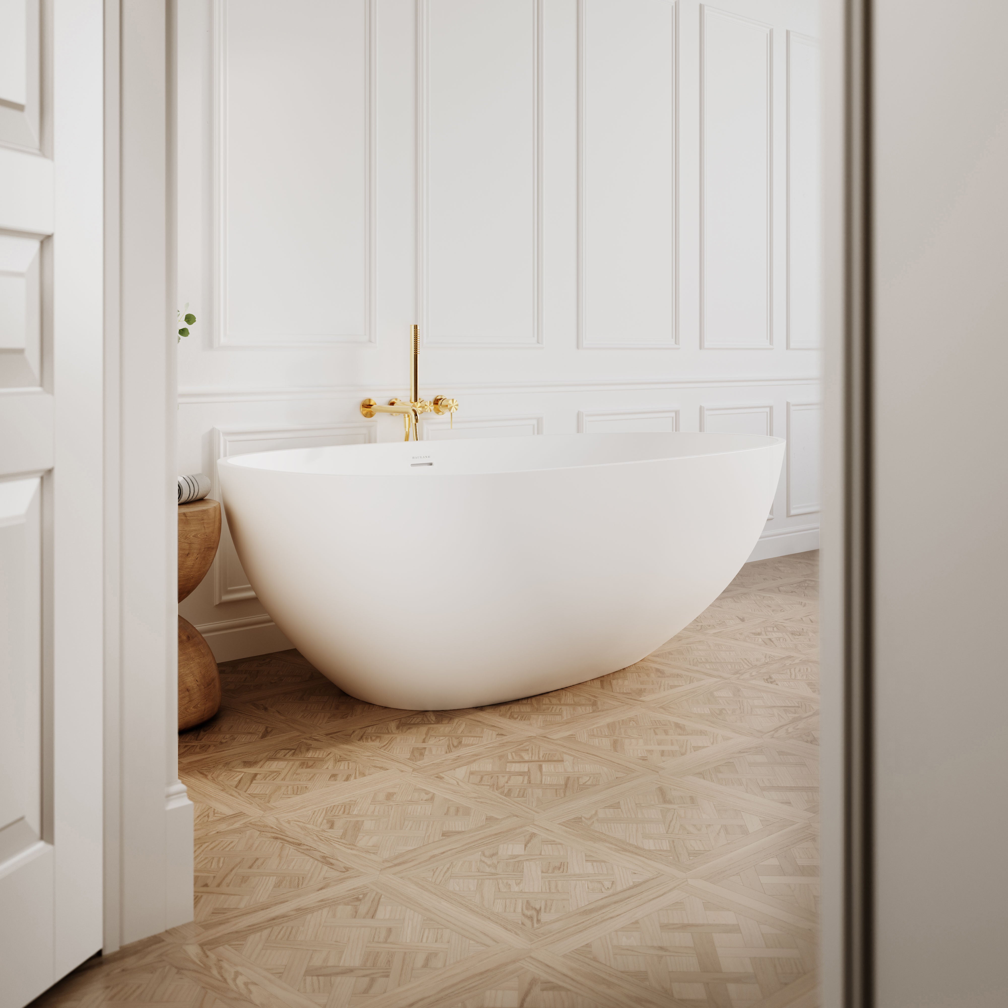 Egg shaped stone resin bath in matte white colour, on parque wood floor, against panelled white wall
